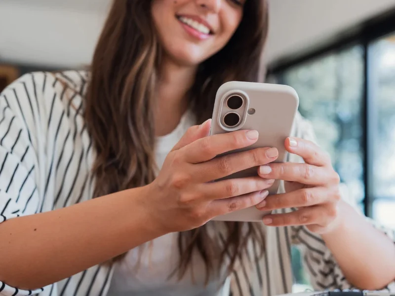 Mujer joven analizando contenidos y foros sobre la femosfera en su teléfono móvil