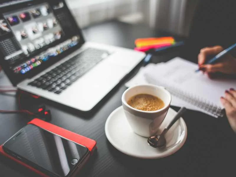 Profesional trabajando en un escritorio ordenado con una taza de café y una agenda abierta