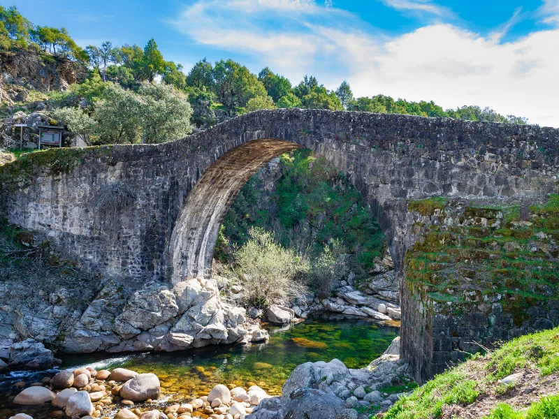 Vista del Puente Viejo del siglo XVIII y la piscina natural de la Garganta de Alardos en Madrigal de la Vera