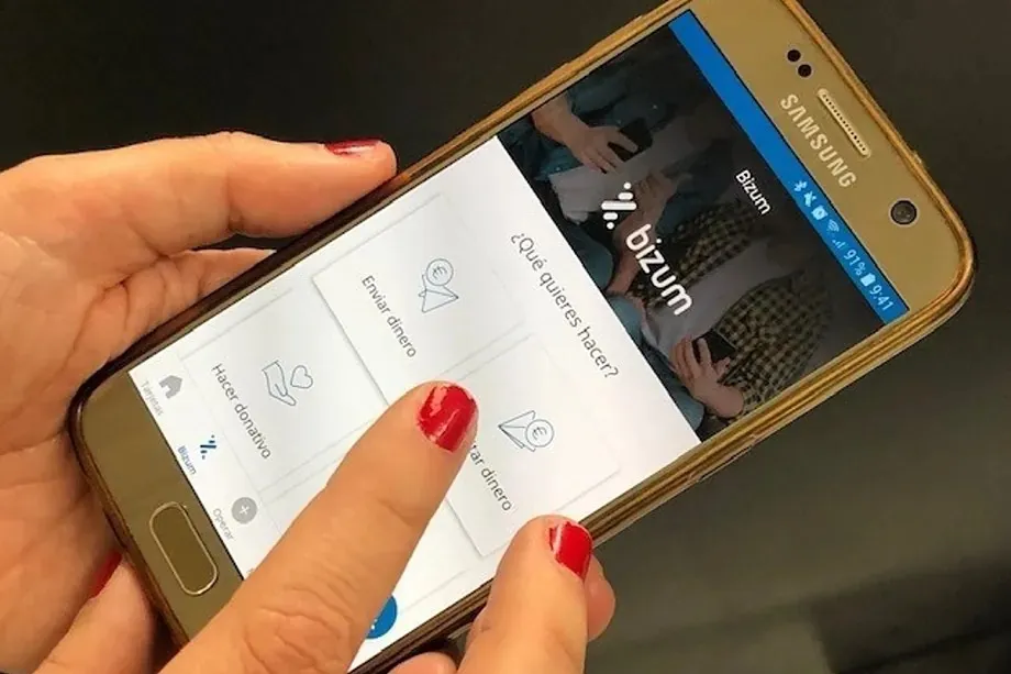 Una mujer, utilizando Bizum desde su teléfono móvil. El Mundo