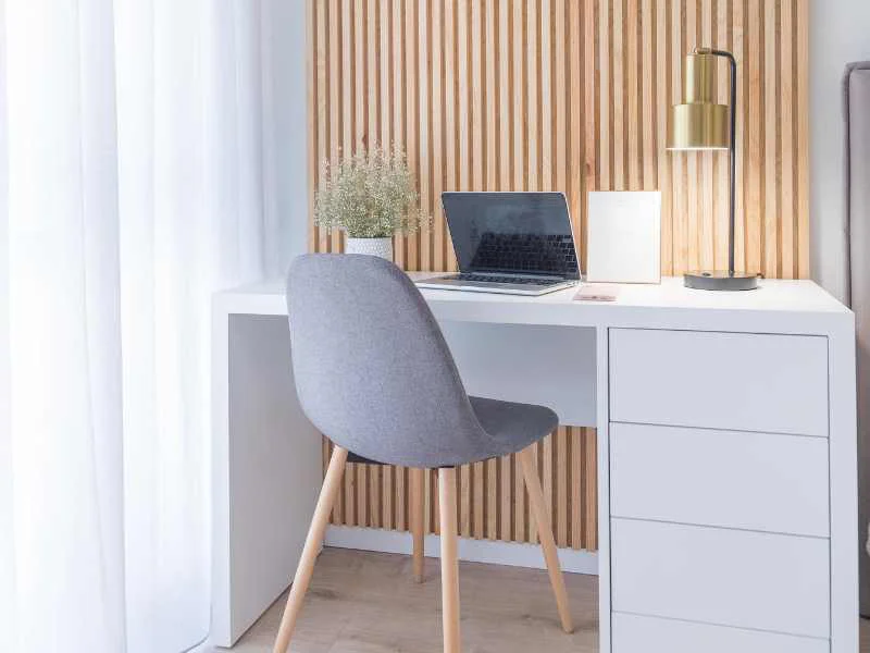 Espacio de trabajo ordenado y luminoso con pocos objetos sobre un escritorio de madera
