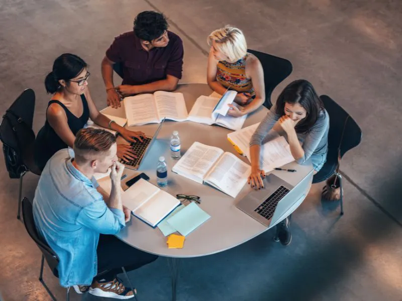 Becas en España Estudiantes universitarios en una biblioteca del campus durante la época de solicitudes de becas en España.
