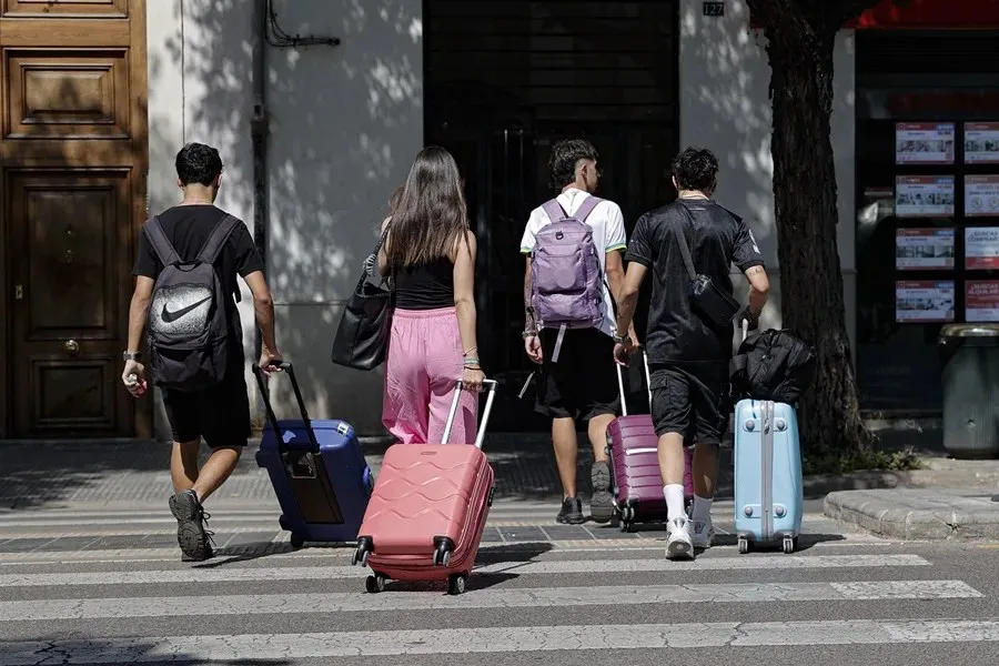 Un grupo de jóvenes camina con sus maletas por una calle de València|Foto: EFE/Manuel Bruque Programa Verano Joven de Transportes: comienza el plazo para apuntarse