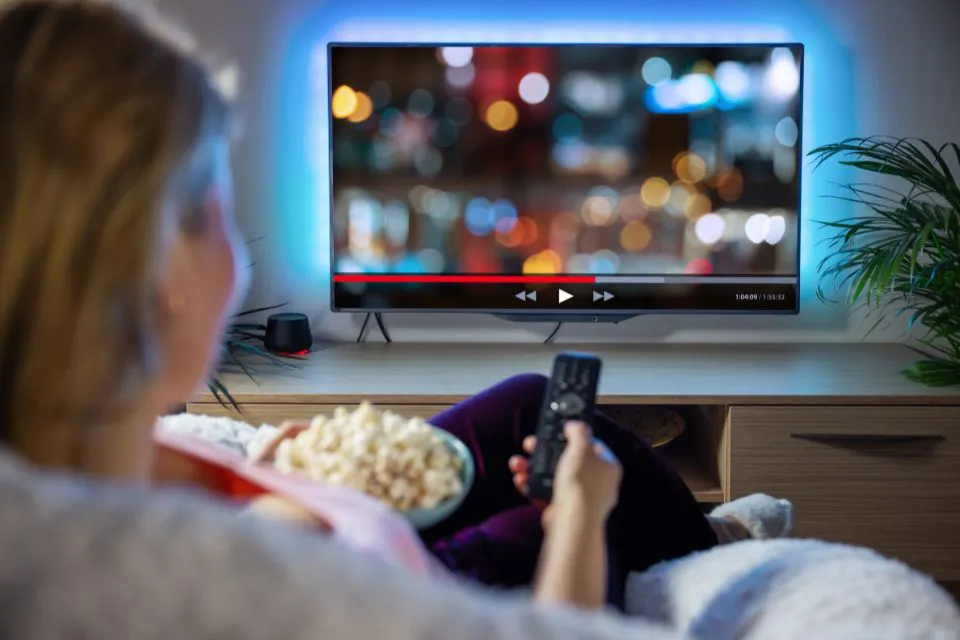 Persona - control de televisión en mano - series de streaming - películas - cine en casa