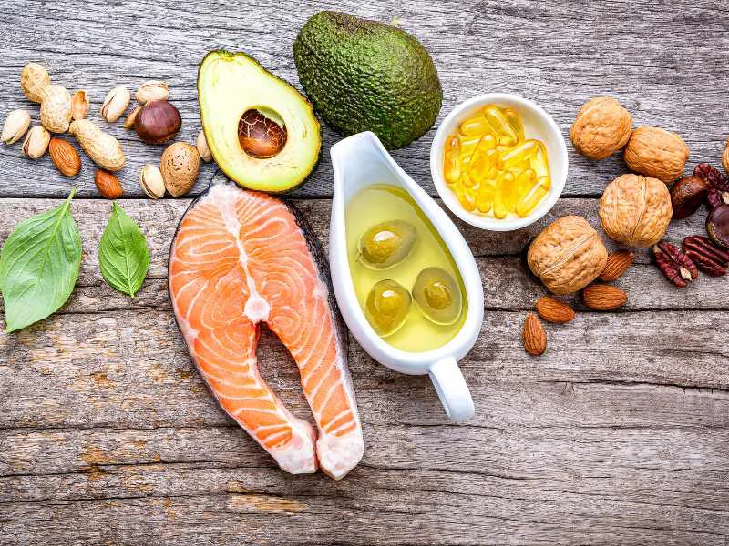 Plato con aguacate, frutos secos, cítricos y salmón fresco sobre una mesa