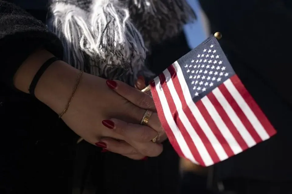 Una persona sostiene una bandera de Estados Unidos (EEUU)|Foto: EFE/EPA/ Bonnie Cash EEUU pone en pausa los trámites de residencia permanente 

