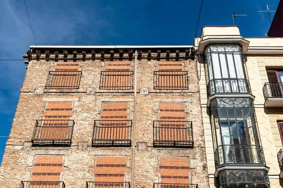 Ventanas de un antiguo edificio residencial tapiadas para protegerlo de okupas|Foto: El Economista iStock Conoce las diez medidas para proteger las viviendas de okupas, según los expertos

