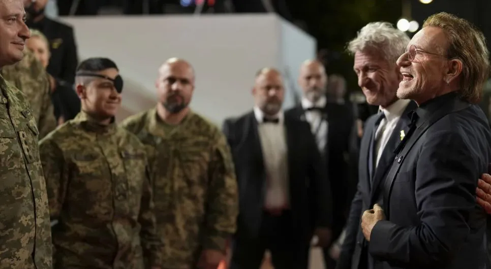 Bono rodeado de soldados ucranianos en el Festival de Cannes|Foto: AP/Natacha Pisarenko Bono protagonizó un emotivo momento en Cannes al desfilar con soldados ucranianos y Sean Penn, mientras presentaba su documental "Stories of Surrender", enviando un poderoso mensaje de paz desde la alfombra roja.
