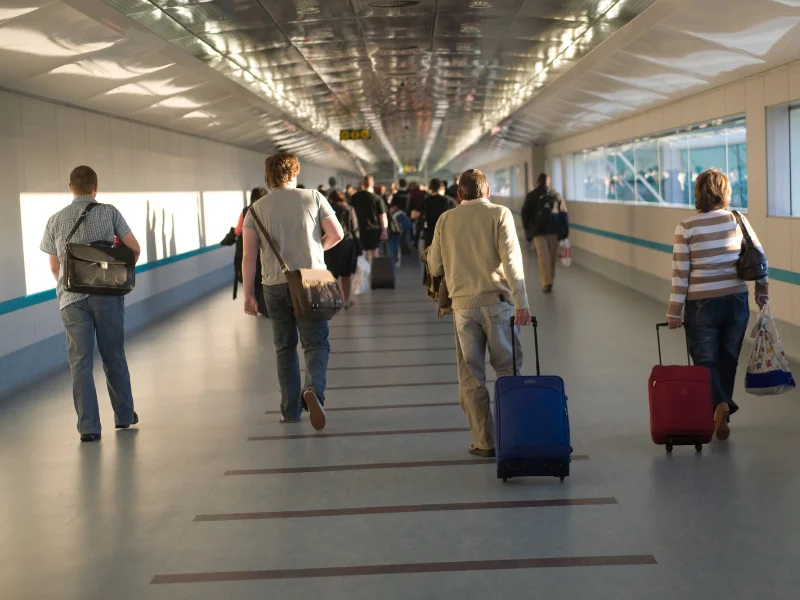 viajeros-con-maletas-caminando-por-la-terminal-de-un-aeropuerto-espanol