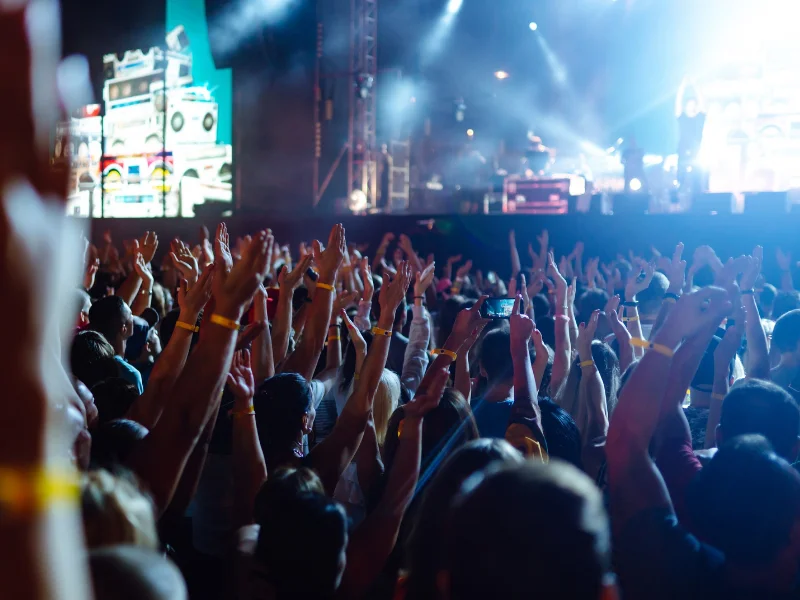 publico-con-los-brazos-alzados-frente-a-un-gran-escenario-de-festival