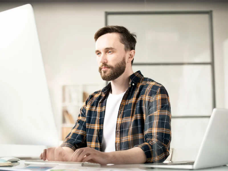 Profesional trabajando frente a una computadora analizando datos y planificando su carrera laboral