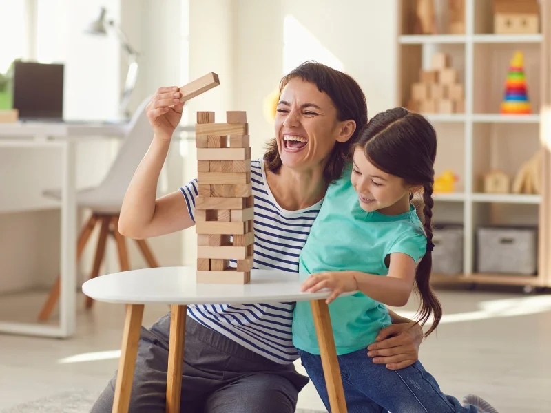 madre-e-hija-pequena-riendo-juntas-durante-un-juego-en-el-suelo-de-casa