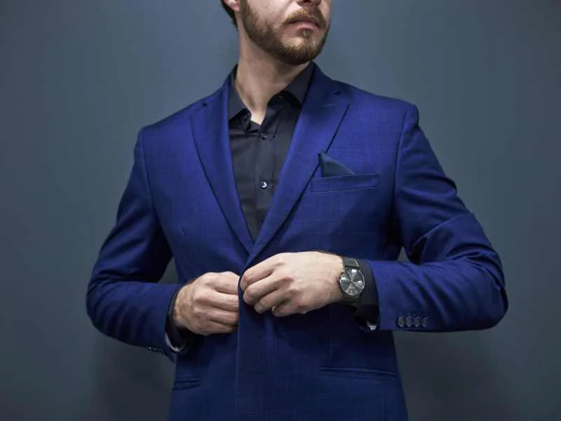 Persona vestida de forma elegante ajustándose un blazer con estilo profesional