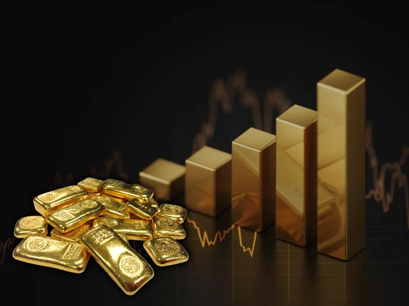 Gráfico financiero de la cotización del oro junto a lingotes de inversión