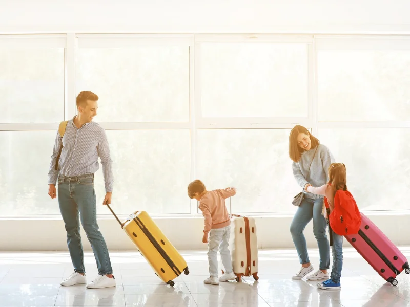 Pasajeros con equipaje caminando por la terminal de un aeropuerto